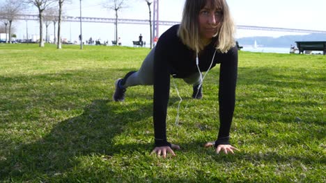 Sporty-girl-doing-plank-exercise-and-stretching-in-park